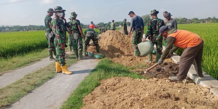 Cuaca Sangat Panas Tak Surutkan Satgas TMMD Rampungkan Pekerjaan.