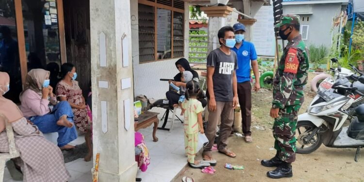 Komsos Dengan Warga Binaan, Serda Wayan Sutrisno Bagikan Masker Dan Sampaikan Prokes.