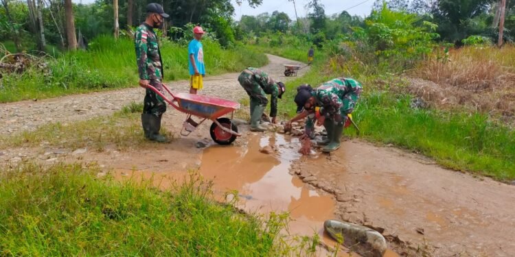 Karya Bhakti Perbaiki Jalan Berlobang Anggota Satgas Yonif 144/JY Bersama Warga Di Perbatasan.