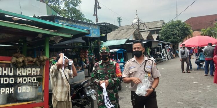 Himbauan PPKM Pasca Nataru Babinsa Bersama Satpam Bagikan Masker Serta Himbauan Prokes di Pasar Klitikan.
