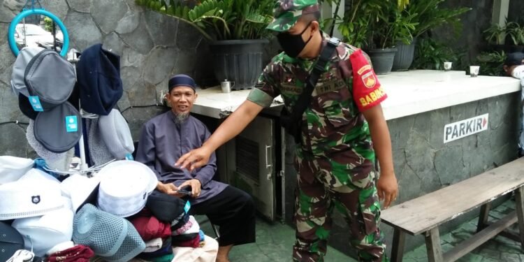 Sertu Rohmad, PPKM Sambil Bagi-bagi Masker di Gedung Fatimah.