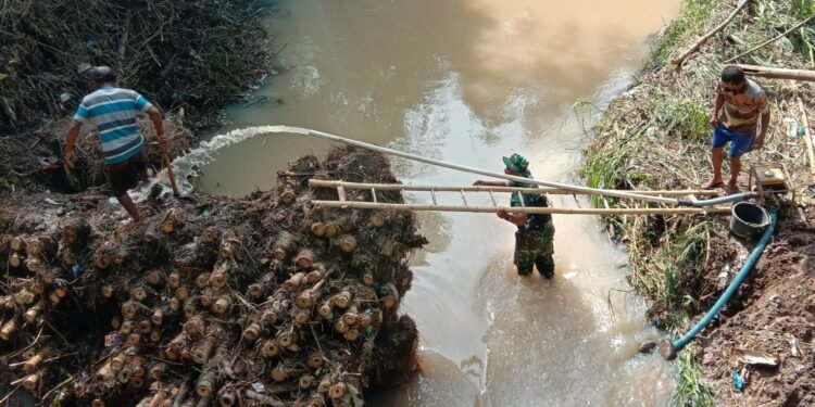 Aliran Sungai Tersumbat, Babinsa Gotong Royong Bersihkan Sampah Pohon Bambu.