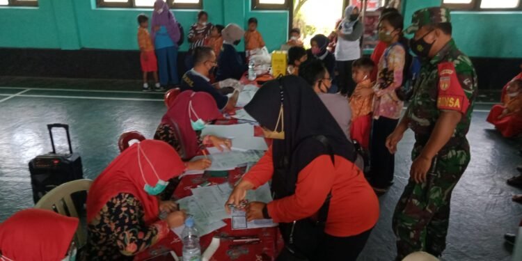 Saling Besinergi, Babinsa Mojorejo Dampingi Vaksin Anak Usia 6-11 Tahun.