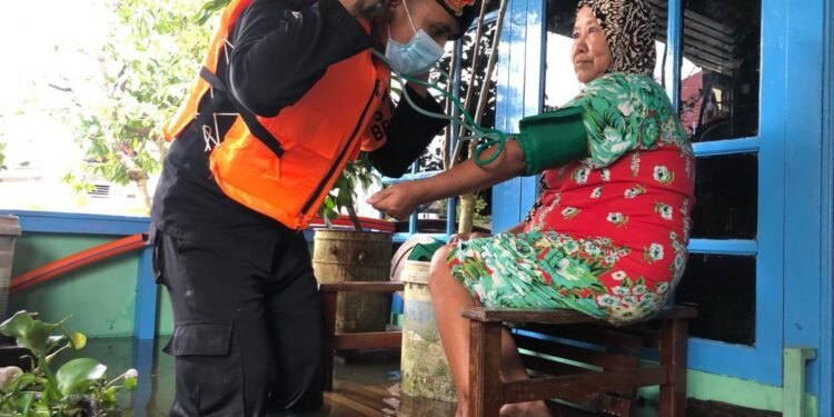 Satbrimob Polda Kalbar Bantu Puskesmas Bagikan Obat-obatan Kepada Warga Korban Banjir.
