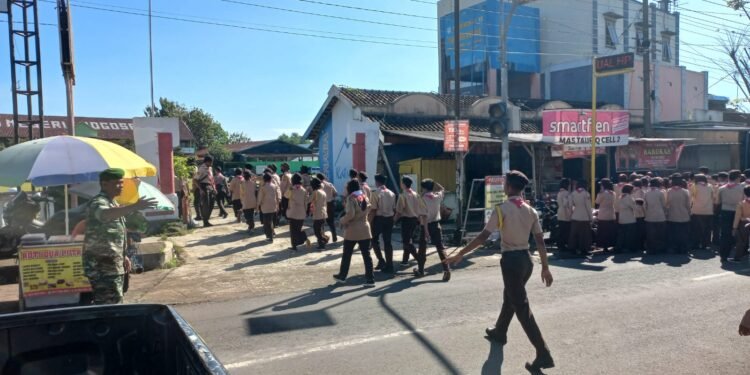 Berikan Rasa Aman, Babinsa Bantu Sebrangkan Anak Sekolah.