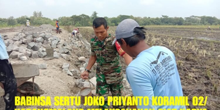 Sembari Bersosialisasi, Babinsa Bantu Kerja Bakti Pengerjaan Talud Irigasi.