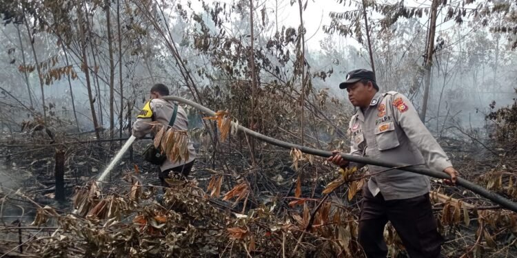 Polsek Tambang Ikuti Giat Pendinginan Bekas Kebakaran Lahan di Wilkumnya.