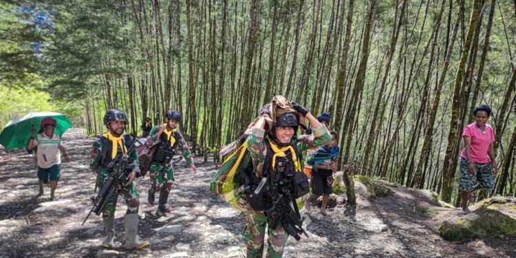 Satgas Mobile Raider 300 Siliwangi Membantu Membawa Barang Mama-Mama Papua